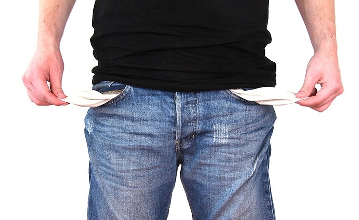 Image contains a man holding the inside of his pockets out.